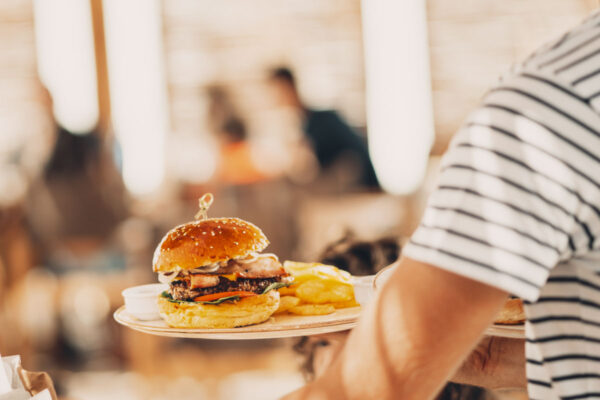 Gourmet burger with bacon, lettuce, tomato, and crispy chips at Naxaki Beach Lounge Restaurant in Naxos