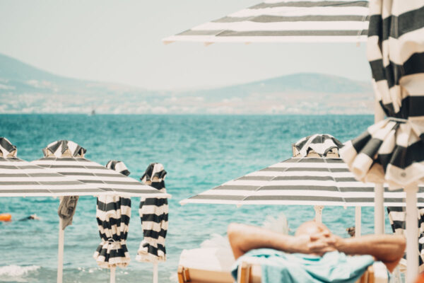 Striped umbrellas with a serene ocean view at Naxaki Beach Lounge