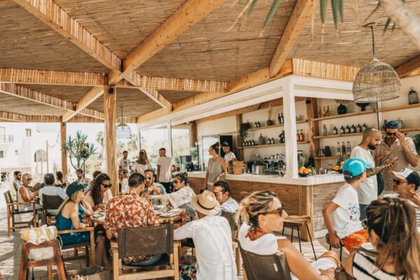 Guests seated near the bar area at Naxaki Beach Lounge Restaurant, enjoying drinks and conversation