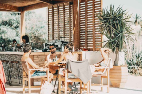 A group of friends sitting and chatting at Naxaki beach lounge restaurant beachside bar area