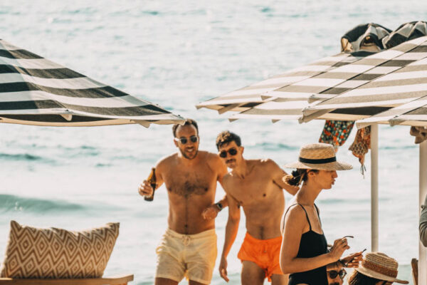 Beach-goers enjoying a sunny day at Naxaki Beach Lounge Restaurant