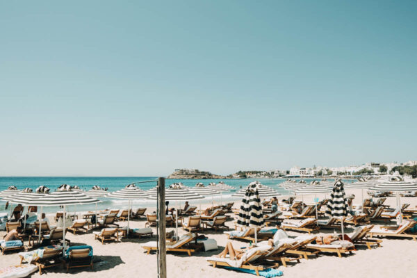 Wide view of the beach setup with sunbeds and umbrellas at Naxaki beach lounge restaurant