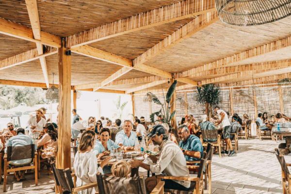 A busy dining area with patrons at Naxaki Beach Lounge Restaurant