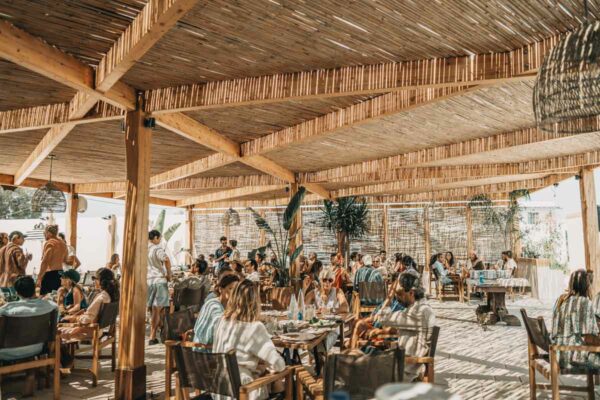 A busy dining area with patrons at Naxaki Beach Lounge Restaurant