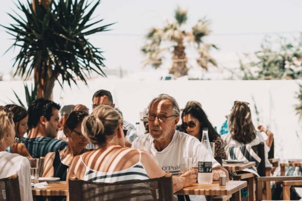 A group of people enjoying a meal together at Naxaki Beach Lounge Restaurant