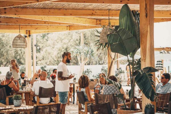 Naxaki beach restaurant with guests dining under a bamboo pergola