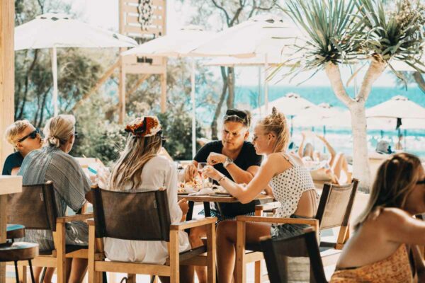 A group of friends sharing a meal and enjoying their time at Naxaki Beach Lounge Restaurant