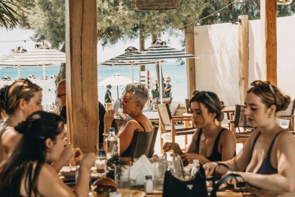 A group of guest dining at Naxaki beach Lounge and Restaurant restaurant with views of the beach and ocean