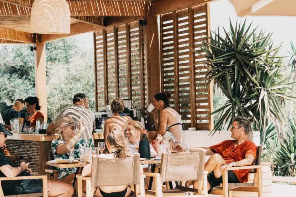 Guests relaxing and enjoying drinks at Naxaki Beach Lounge Restaurant's shaded area