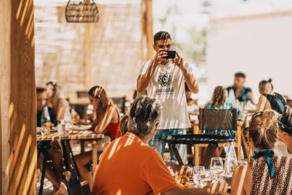 A server taking a photo of happy restaurant guests