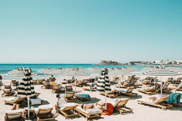 Sunbeds and striped umbrellas on the beach at Naxaki beach lounge restaurant