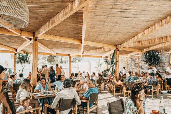 Dining under a wooden canopy at Naxaki Beach Lounge Restaurant