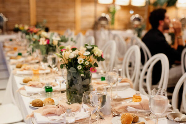 Beautifully decorated reception tables with flowers and place settings for a wedding at Naxaki Beach Lounge and Restaurant