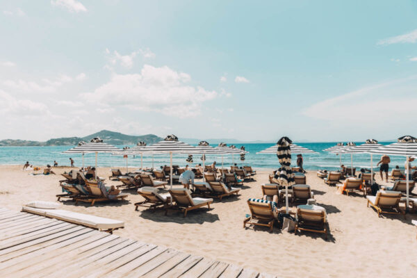 Sunbeds and umbrellas on the pristine sands of Naxos at Naxaki Lounge and Restaurant, offering a perfect seaside retreat