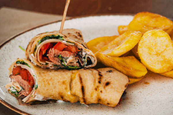 Tasty beef wrap with fresh vegetables and crispy potato chips at Naxaki Beach Lounge Restaurant in Naxos